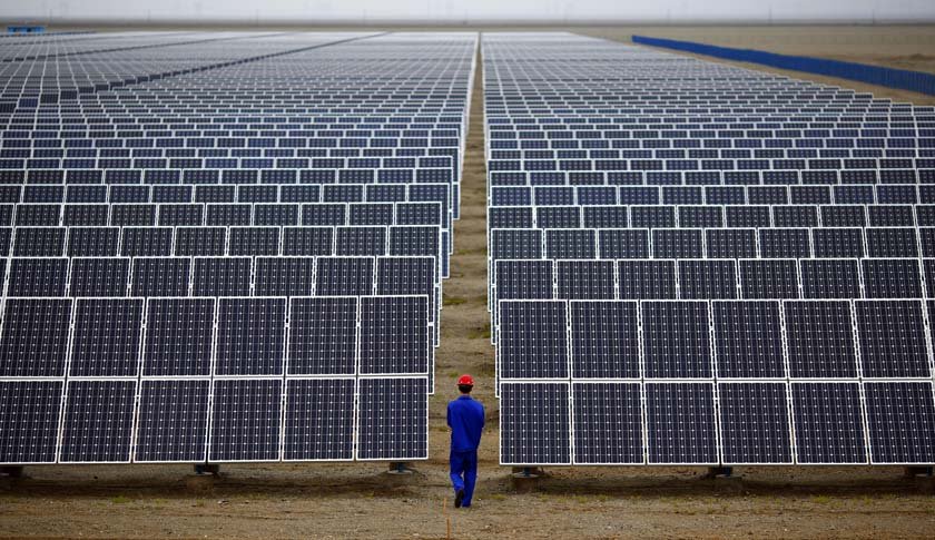 4 1 - A worker inspects solar panels at a solar farm in Dunhuang, 950km northwest of Lanzhou, Gansu Province